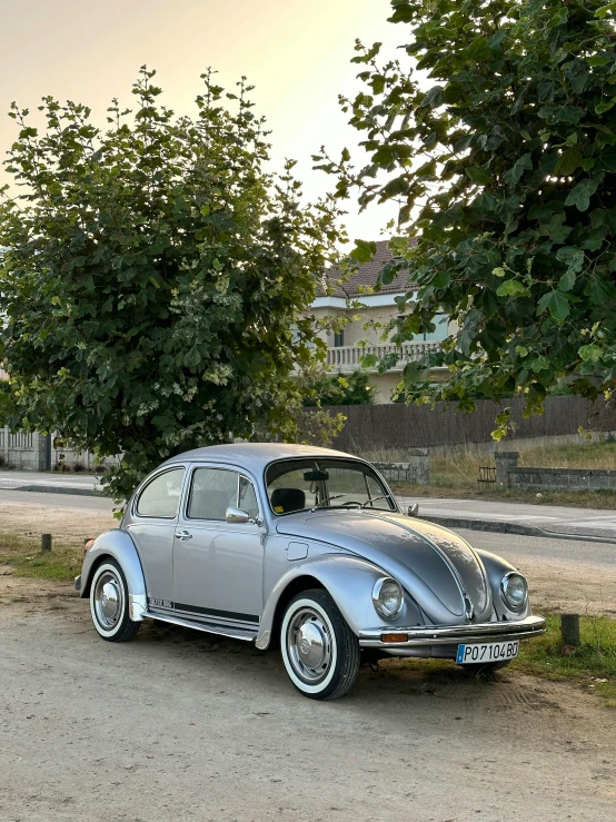 old car parked in the shade on a road