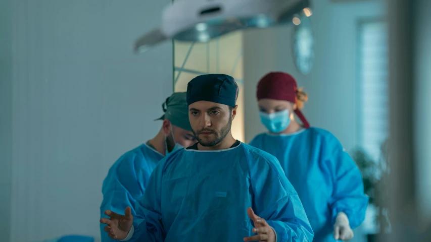 a group of doctors standing inside a hospital with blue clothes