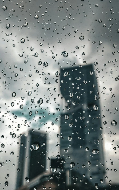 a view of skyscrs through a rain covered window