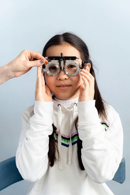 a girl holding up two pairs of glasses