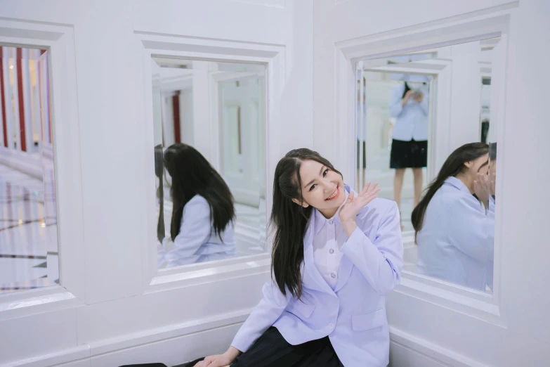 a woman sitting in front of two mirrors brushing her teeth