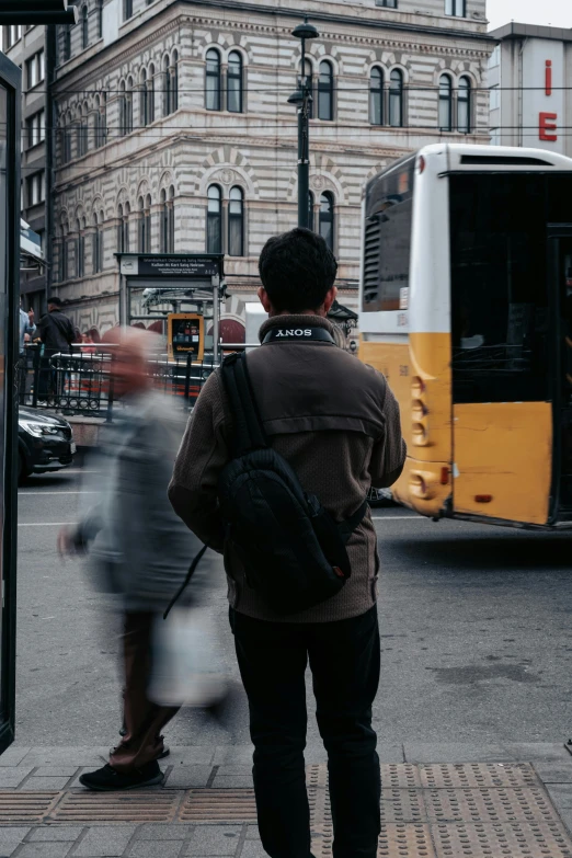 man getting on his bus from another bus in front of it