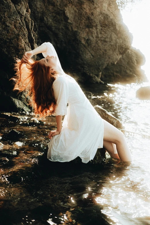 a beautiful woman is sitting in water on the beach