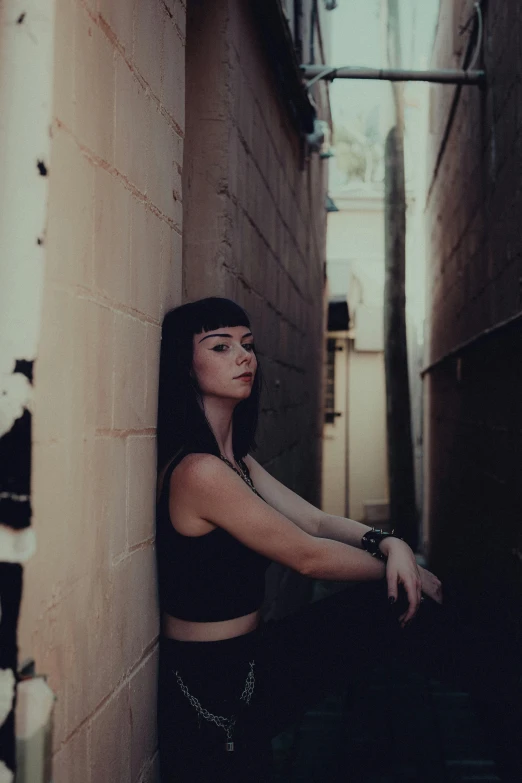 a woman leaning against the wall with her arm on the ledge