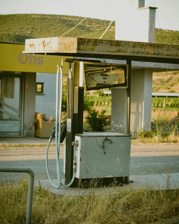 old style gas pump next to road with building