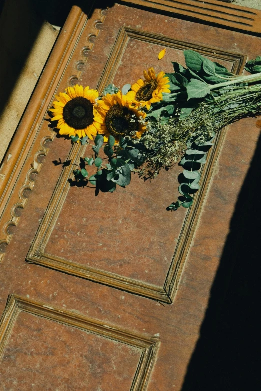 sunflowers are laying on a piece of leather