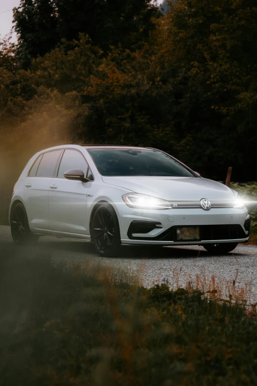 white car driving down the road in fog