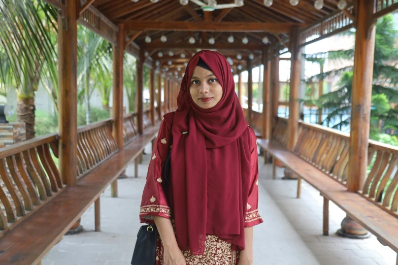 a beautiful woman standing in front of a wooden structure