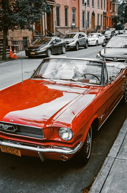 an old car in the street with buildings around it