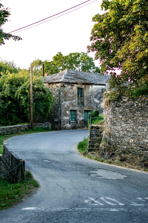 an old stone building on the side of a dirt road