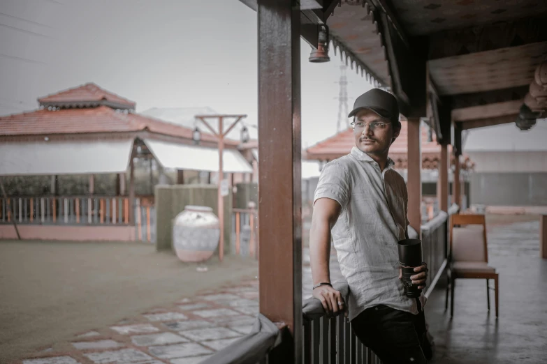 a man wearing a hat next to a fence