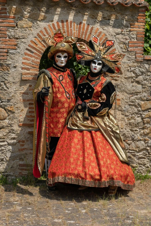 two people dressed in masks and sitting next to each other