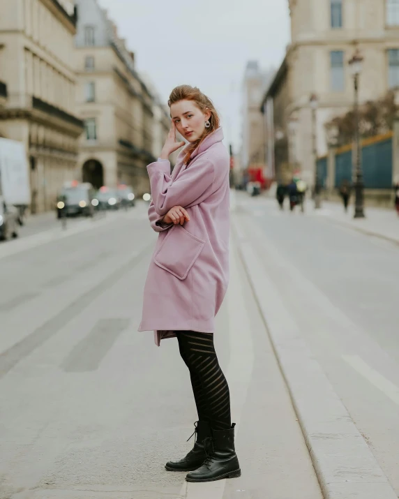 a  in a pink coat and boots poses