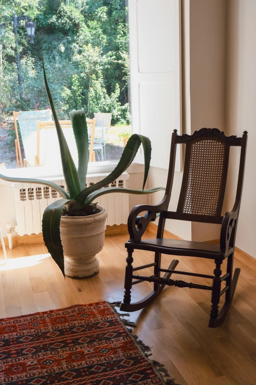 a wooden rocking chair in front of a window