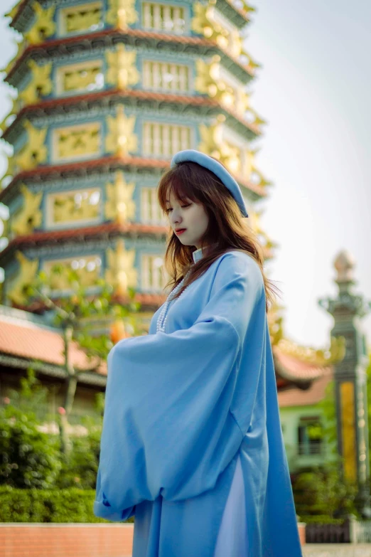 a young lady posing for a po in front of a pagoda