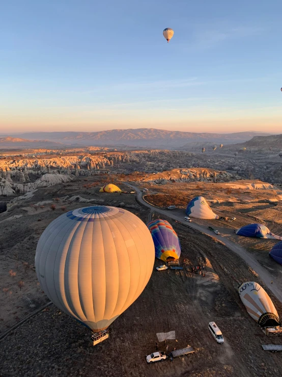 several  air balloons rise in the sky above other balloons