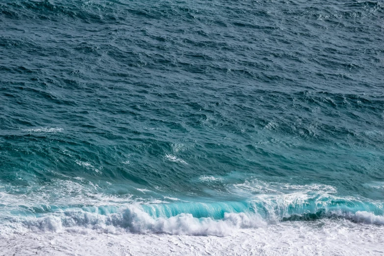 an overhead view of the ocean with blue waters