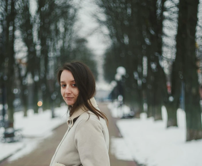 a woman in a jacket is walking down the snow