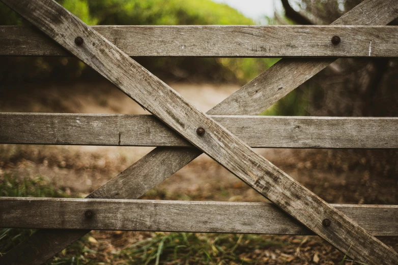 a wooden fence with horizontal rail in an open field