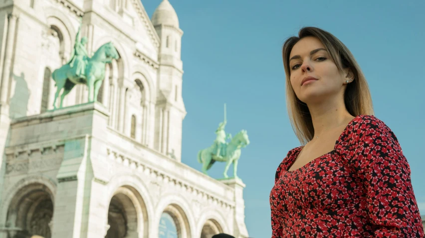 a beautiful young woman standing near a building looking up at the sky