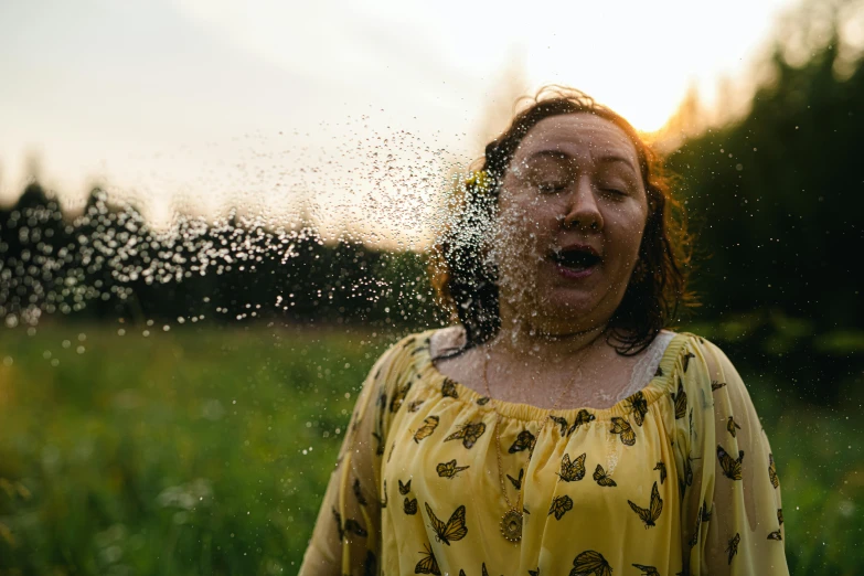 the woman is in the field splashing water on her face