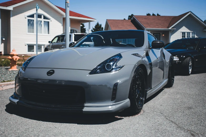 a silver car with black wheels parked in front of a house