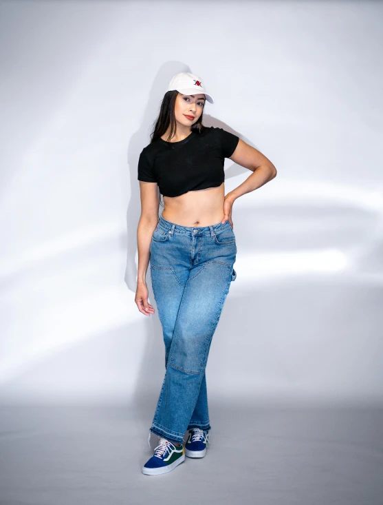 a woman wearing a baseball cap and blue jeans