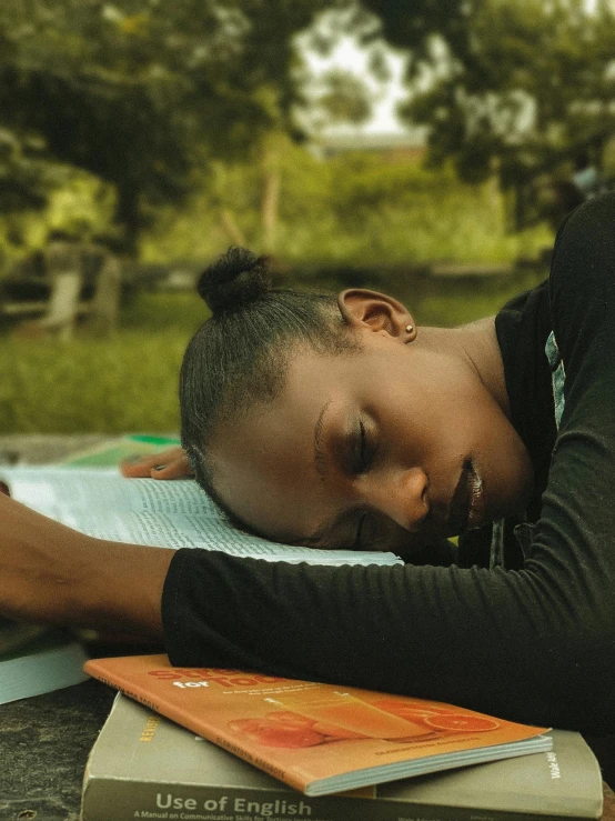 a man resting his head on a book