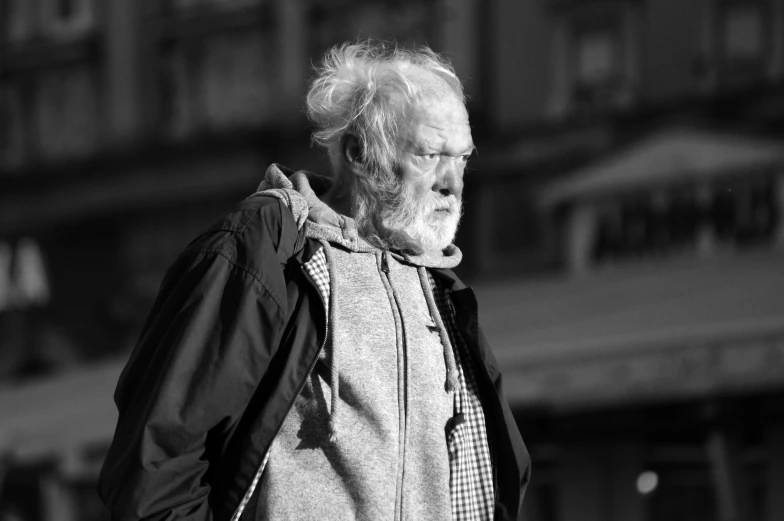 an elderly man wearing a hoodie and running in the city