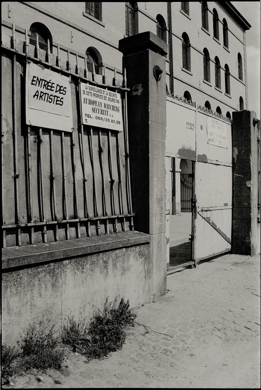 an old building with fencing and signs attached to the side