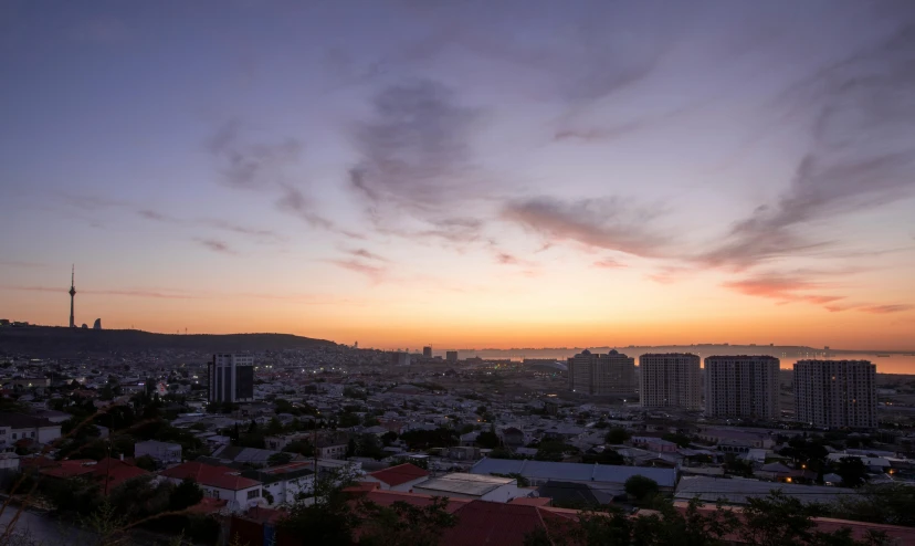 the sun setting over some buildings in a city