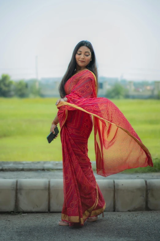 a woman in red holding a piece of sari