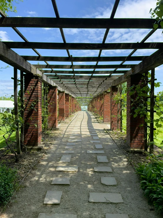 a long walkway with several trees and some bricks