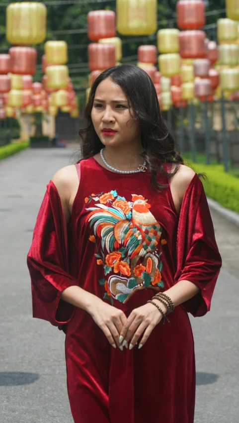 a woman with dark hair and large  wears a red dress, a matching necklace and earrings