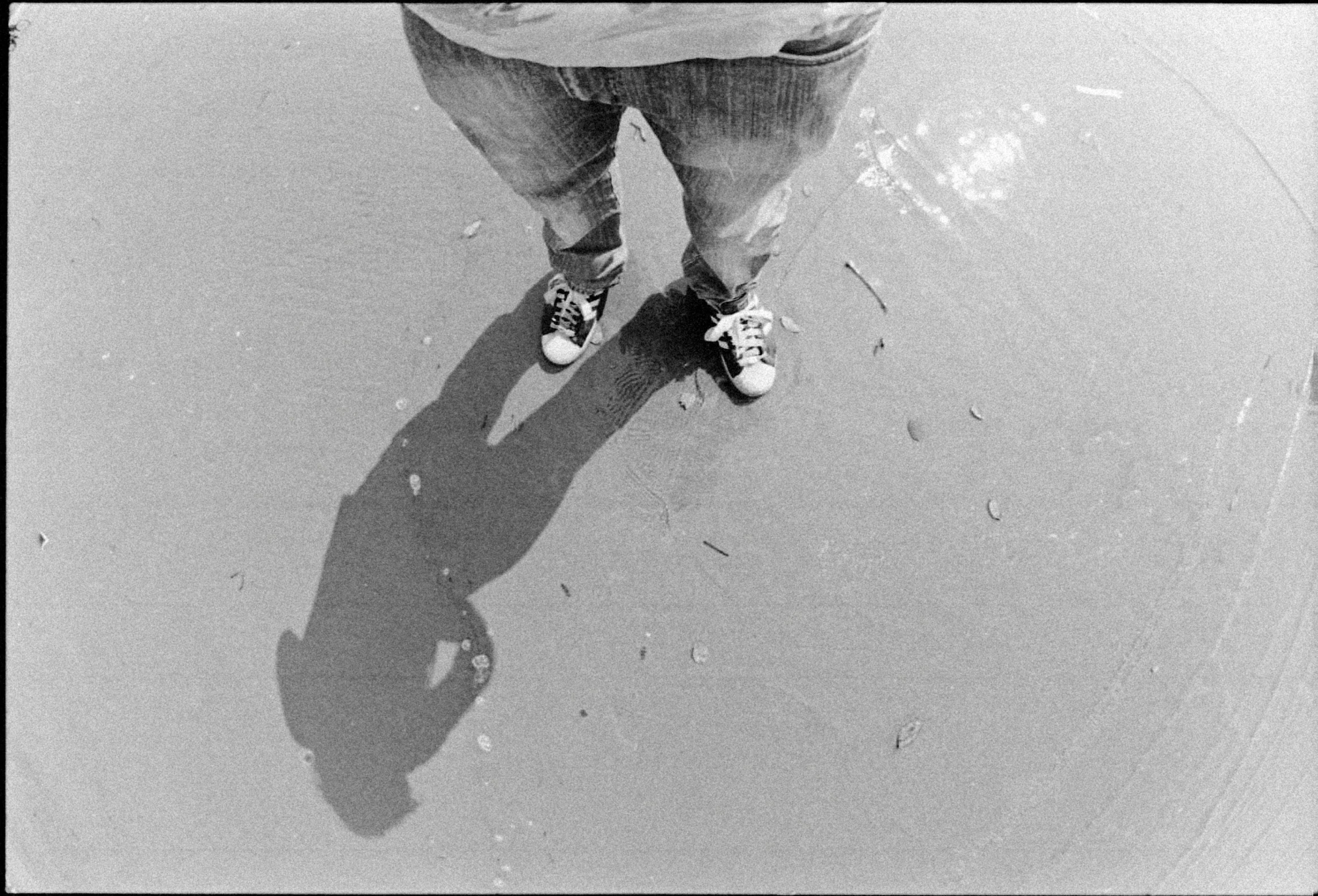 an aerial s of someone's feet and shoes in the sand