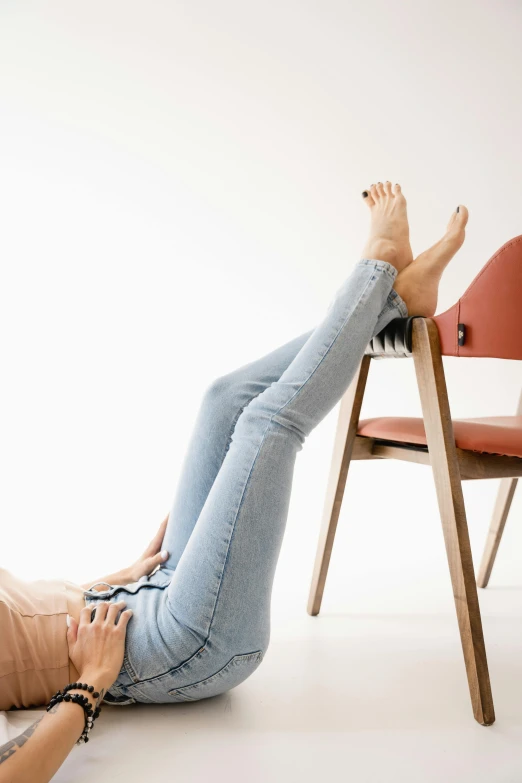 a woman with her legs crossed laying on a chair
