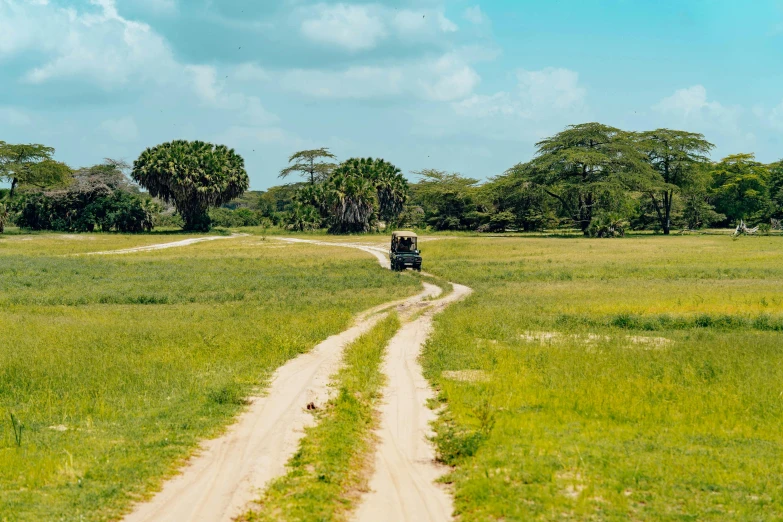 a jeep drives down the road on a dirt road