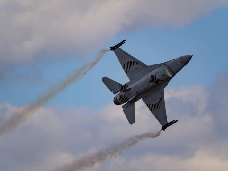 an airplane flying with smoke coming from it is leaving trails behind it