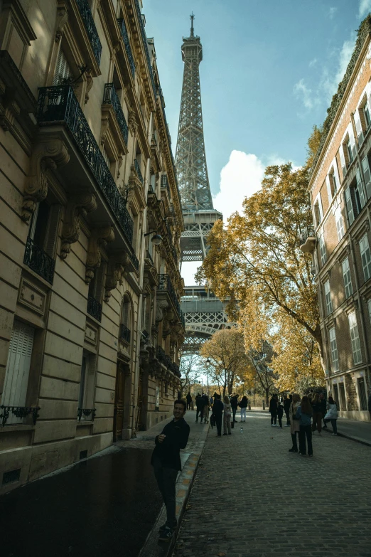 a crowd of people on an alley near the eiffel tower