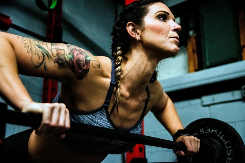 a woman squatting with barbells inside a gym