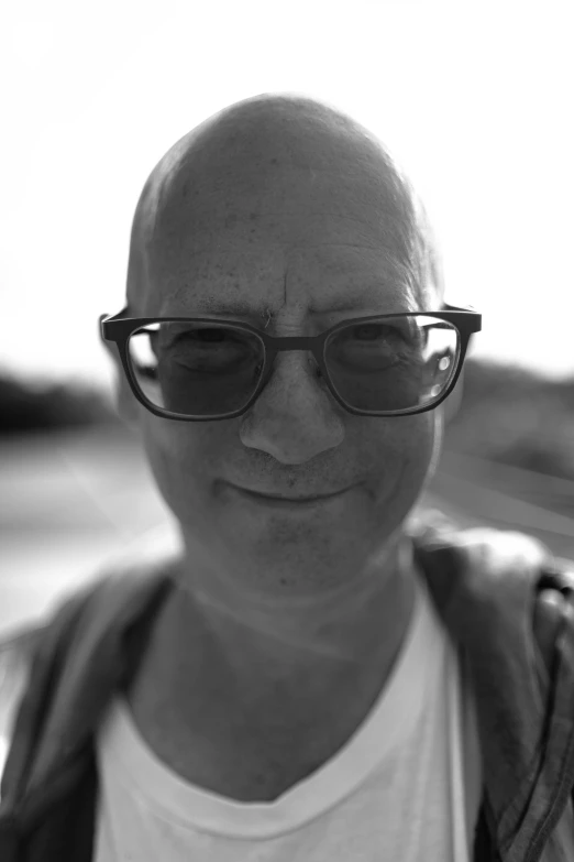 a man with glasses staring in to the camera