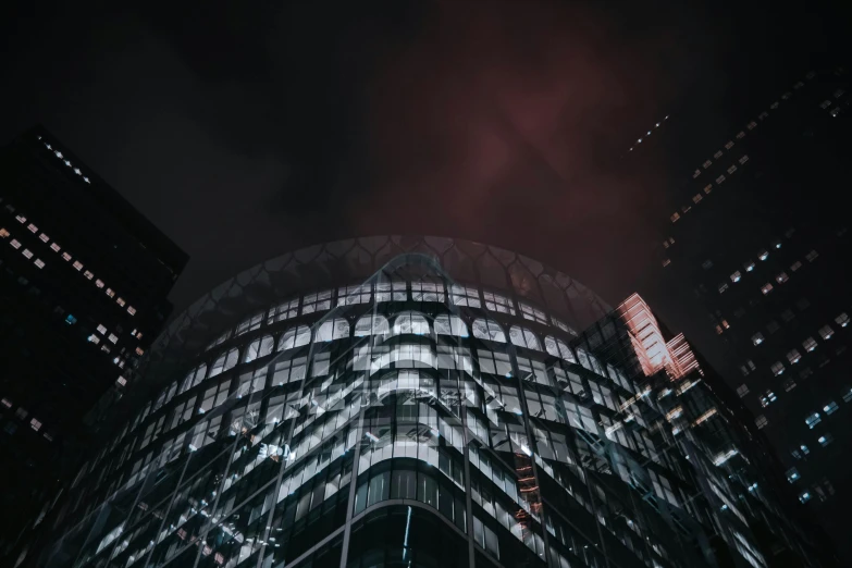 the corner of a building with windows at night