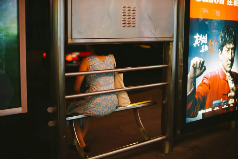 a woman sitting next to a rail on a train