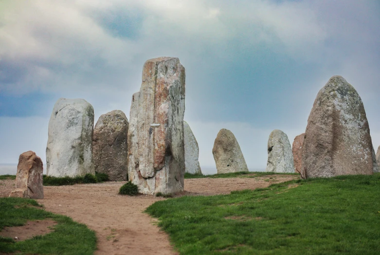 the landscape is filled with stonehenches and a dirt path