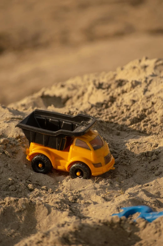 there is a toy car that is in the sand