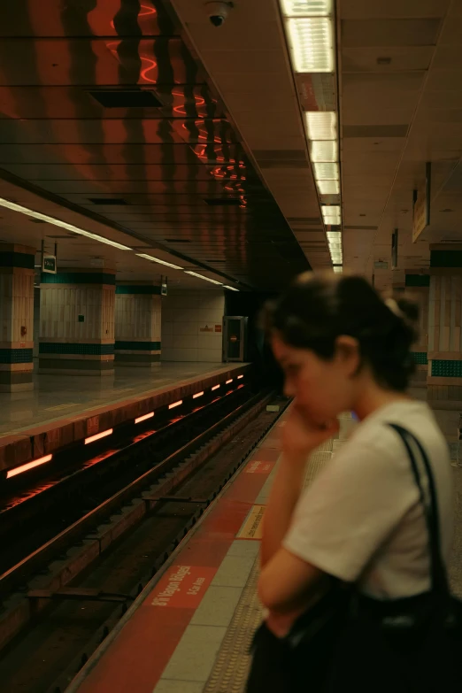 a woman looks out over the subway tracks