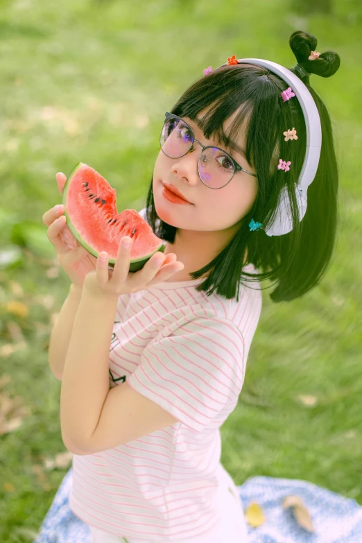 a little girl holding two pieces of watermelon