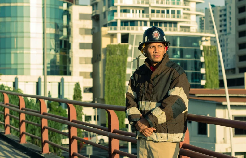 man in safety gear standing on metal bridge over river