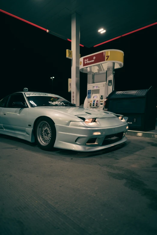 a white car in the parking lot at a gas station