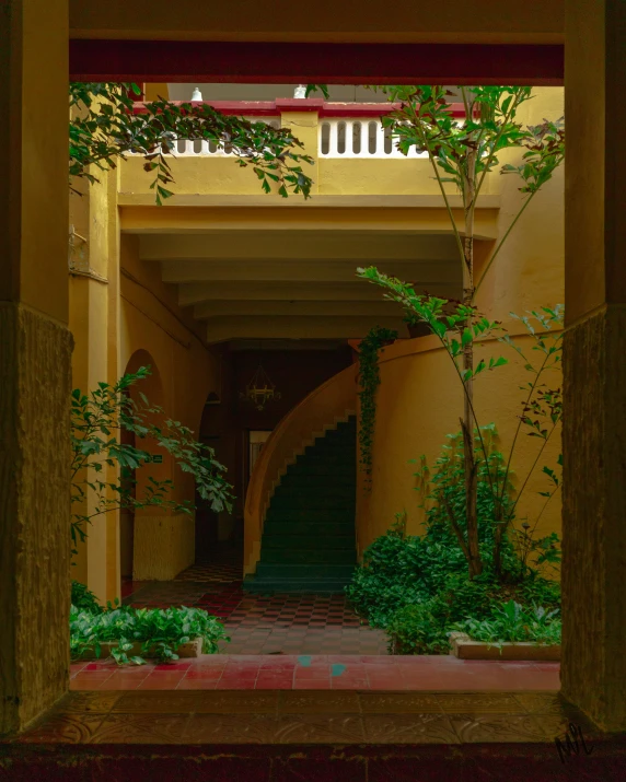 an empty walkway in a large yellow building with a clock